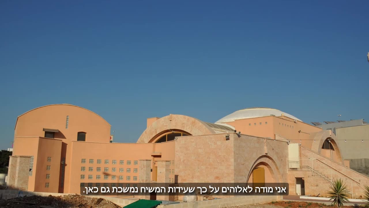David Tzadok, the congregation's pastor, speaking in the sanctuary with a name title on screen